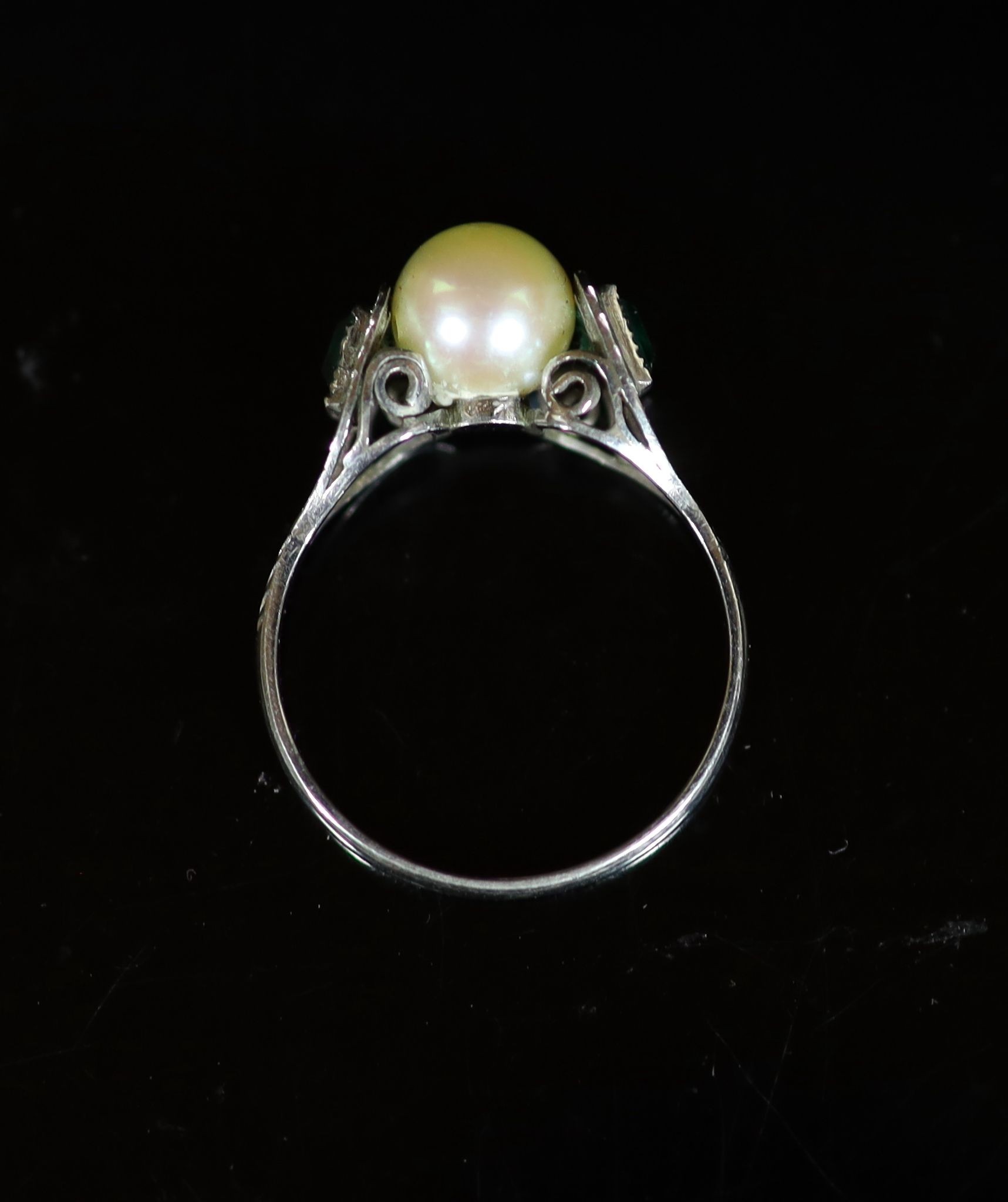 A mid 20th century white gold, cultured pearl and emerald set three stone ring